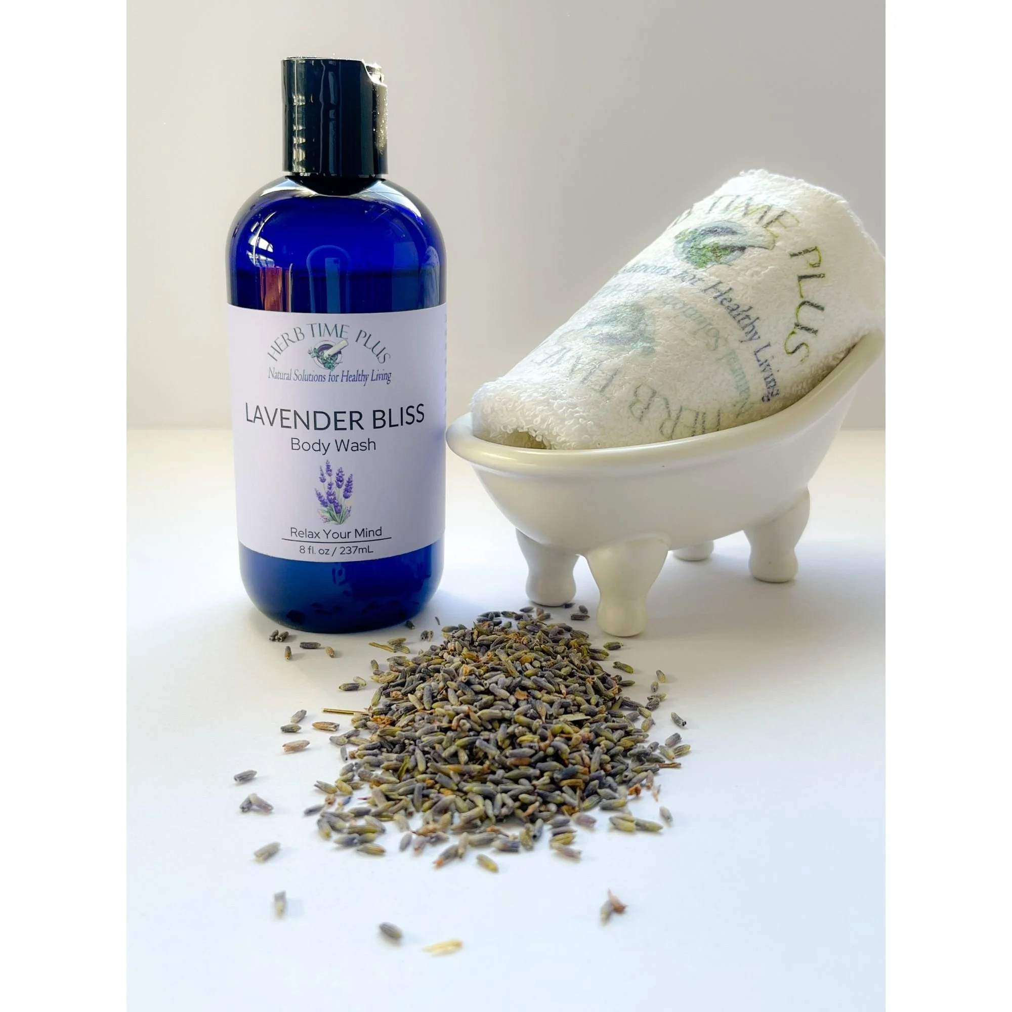 lavender-bliss-body-wash-display.jpeg: lavender bliss body wash in bottle with lavender flowers and mini bathtub soap dish