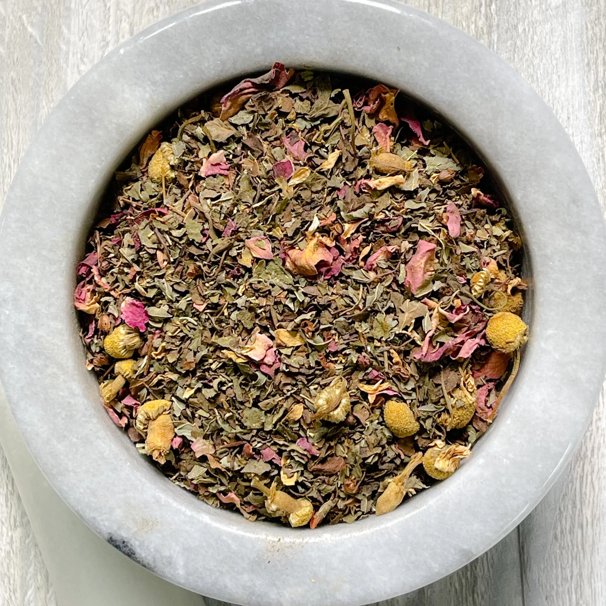 deep-calm-tea.JPEG: a light marble mortar on a counter filled with deep calm tea