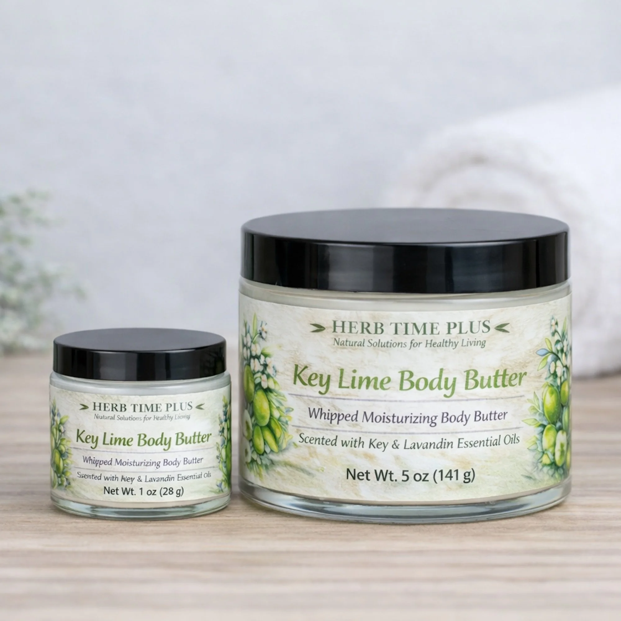 key-lime-body-butter.jpg: two jars of key lime body butter 1 oz and 5 oz on a table with a towel behind
