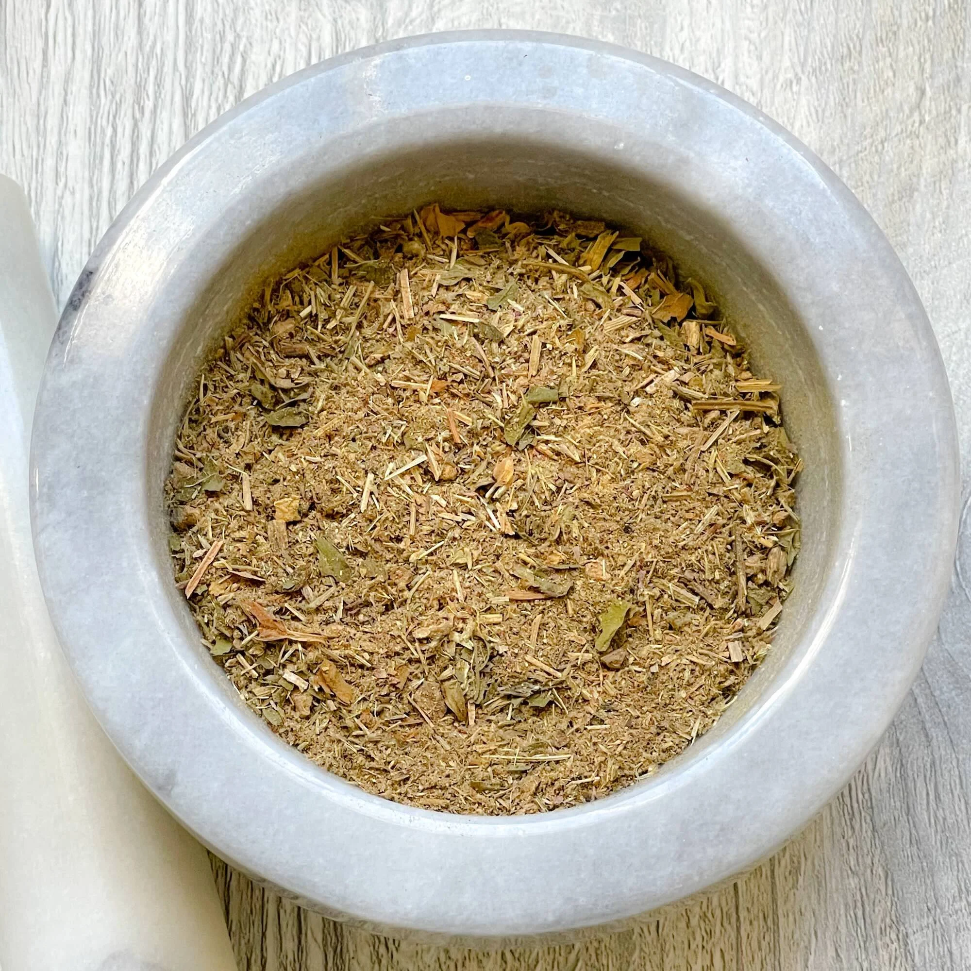essiac-plus-herbal-tea-blend-loose.jpeg: loose essiac plus herbal tea blend in a mortar