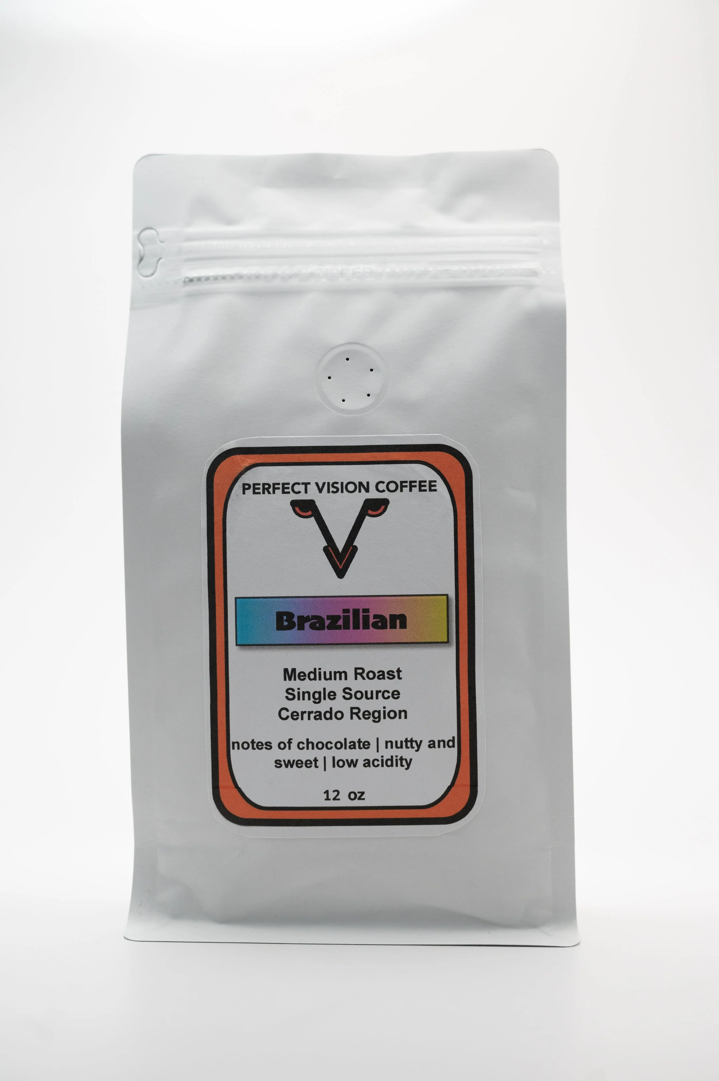 White coffee bag labeled Perfect Vision Coffee Brazilian medium roast single origin from Cerrado region with notes of chocolate, nutty and sweet, low acidity, 12 ounces.