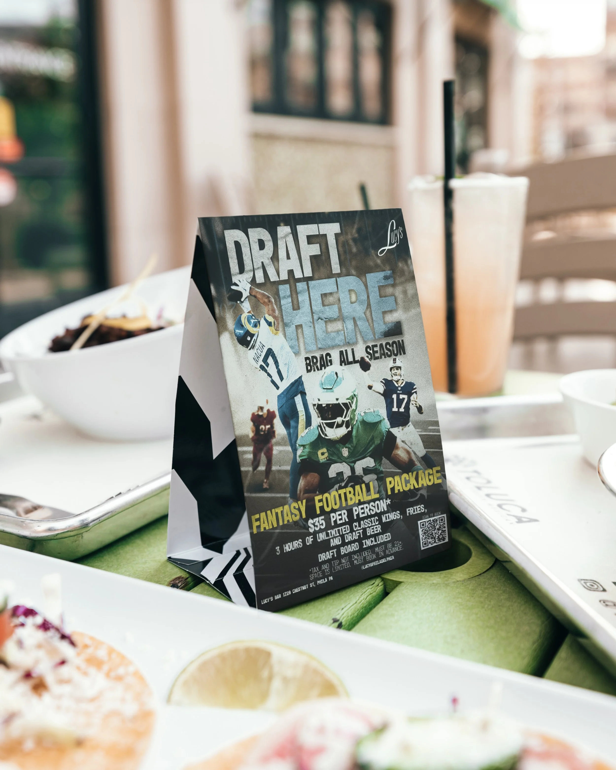 A table menu for a fantasy football draft package at Lucy's restaurant, featuring football player images and text about the package deal.