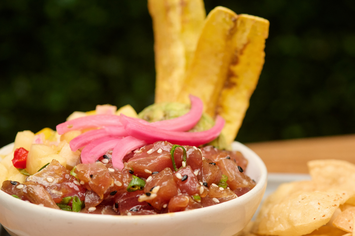 Fresh yellowfin tuna tossed in house made poke sauce, scallions, sesame seeds, over coconut rice, topped with guacamole, mango pineapple salsa, plantain chips & pickled onions, with tortilla chips on the side