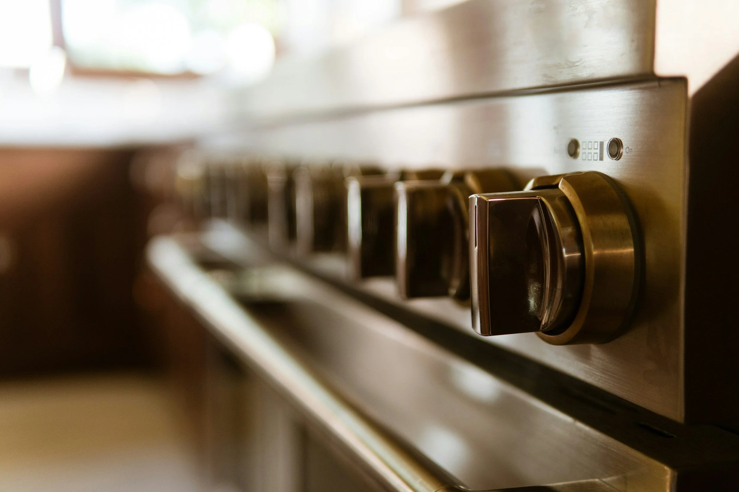 Close-up of a stainless steel gas stove burner and control knob.
