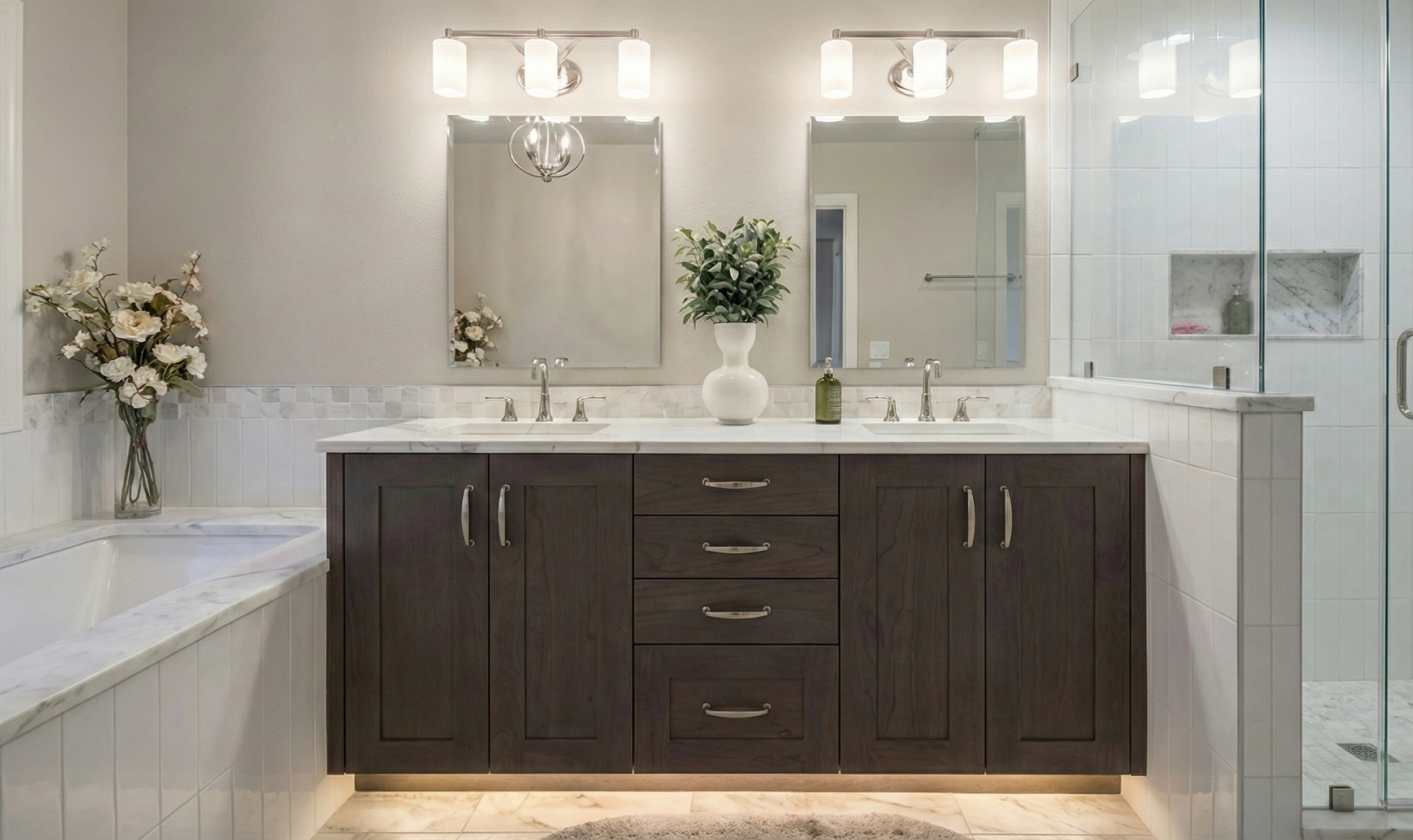 Modern bathroom with dual sinks, large mirrors, decorative flowers, and a glass shower enclosure.