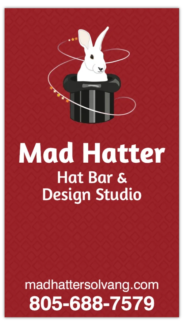 Red business card for Mad Hatter Hat Bar & Design Studio, featuring a white rabbit peeking out of a black top hat with swirling stars around it, the business name in bold white letters, website, and phone number.