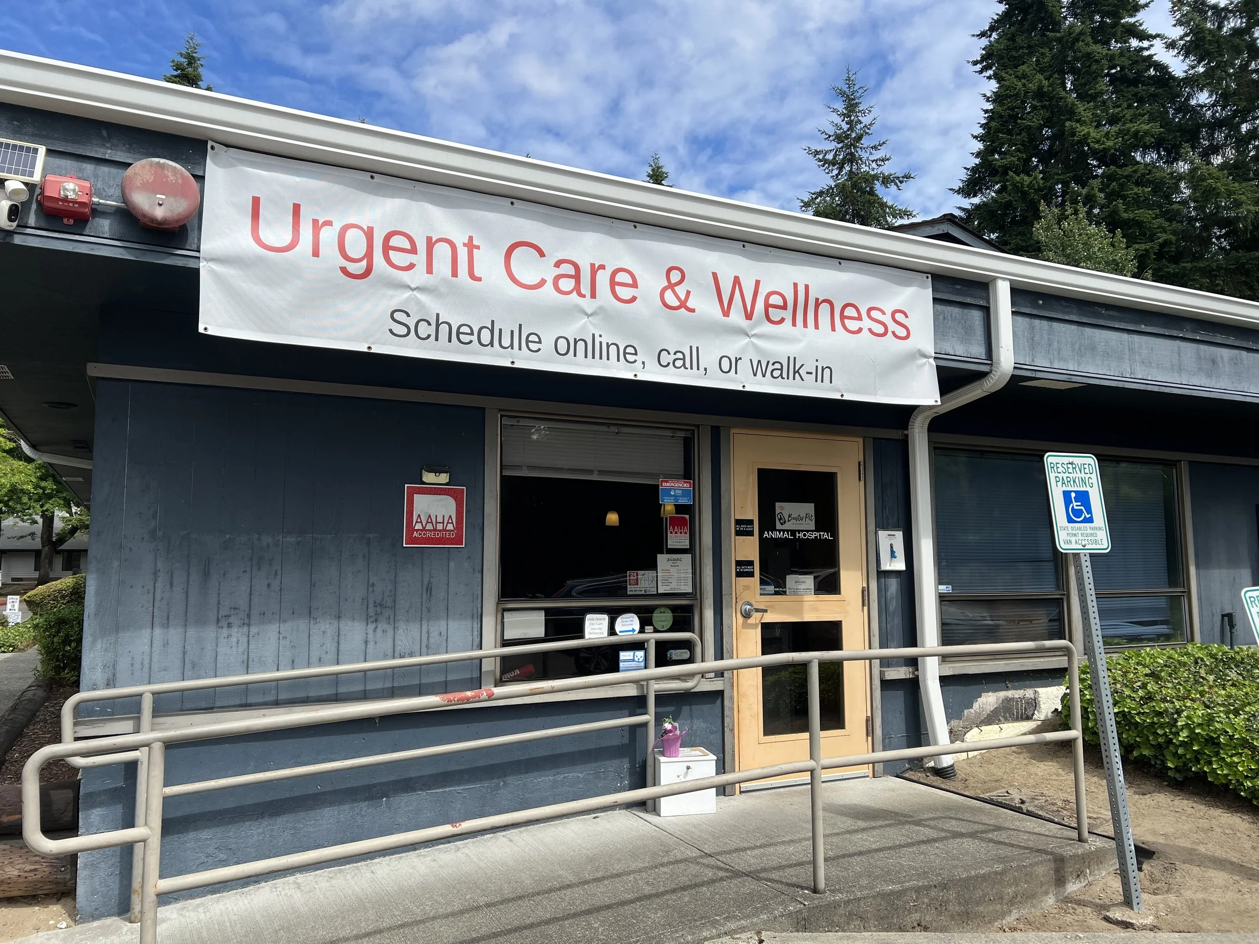 Outside of an urgent care and wellness clinic with a large sign that reads 'Urgent Care & Wellness' and 'Schedule online, call, or walk-in.'