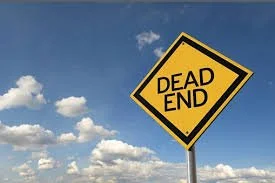 Yellow diamond-shaped sign with black border and text that reads "Dead End" against a blue sky with clouds.