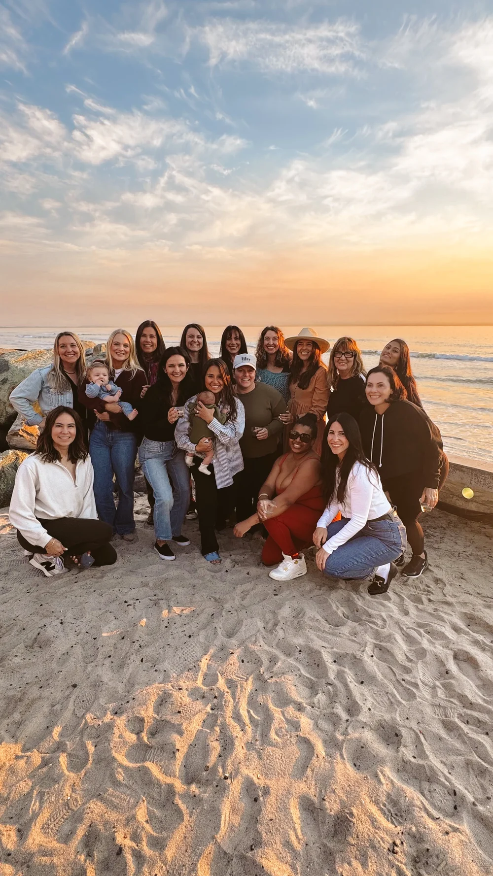 Women and kids at the beach at sunset