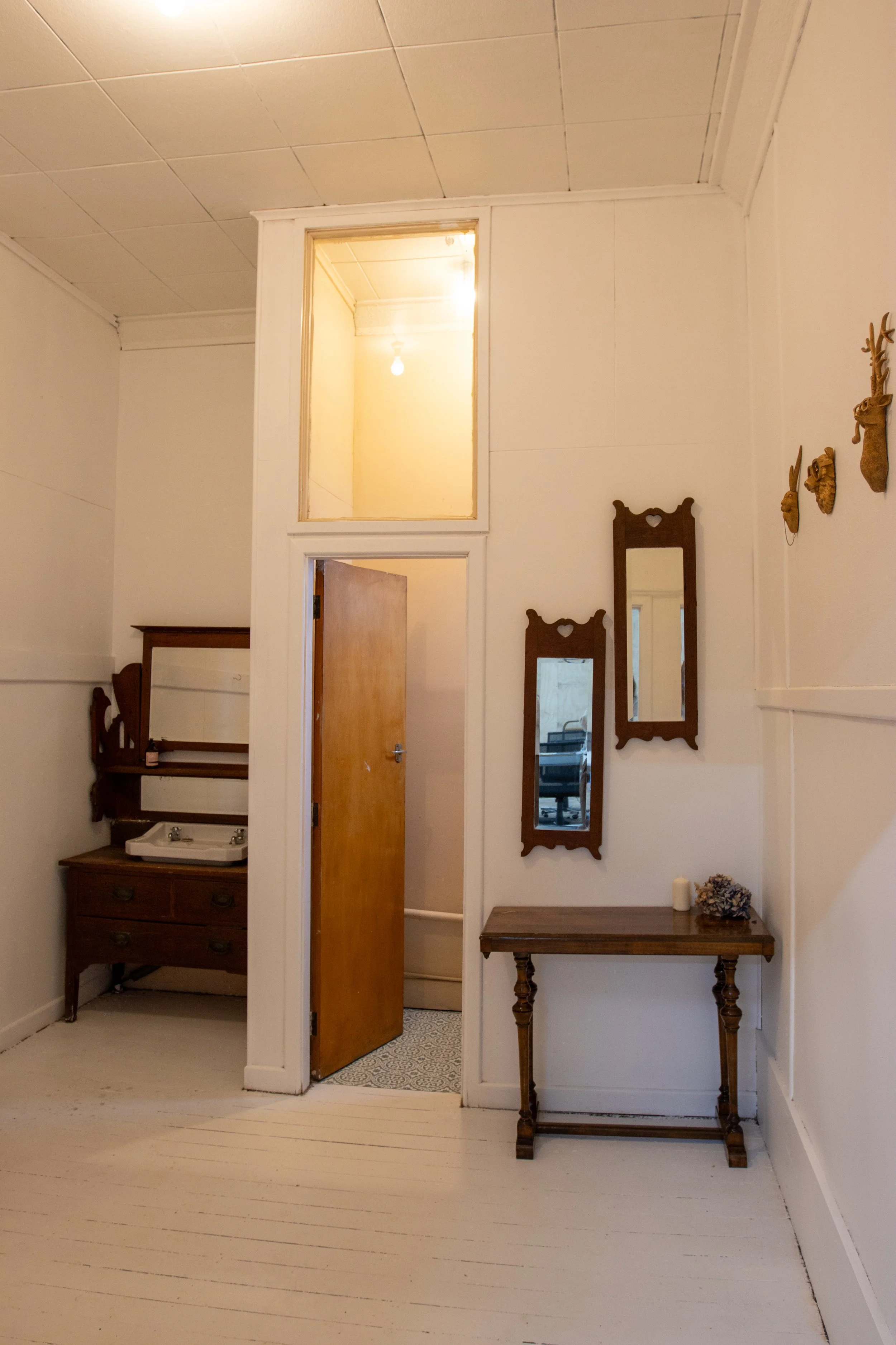 Bathroom of the event space with wooden accents like a table and a door.