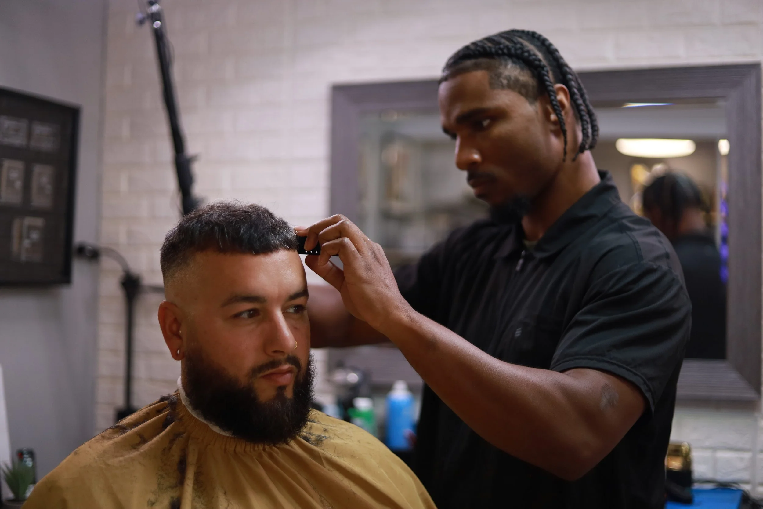 Barber trimming a man's hair in a barbershop.