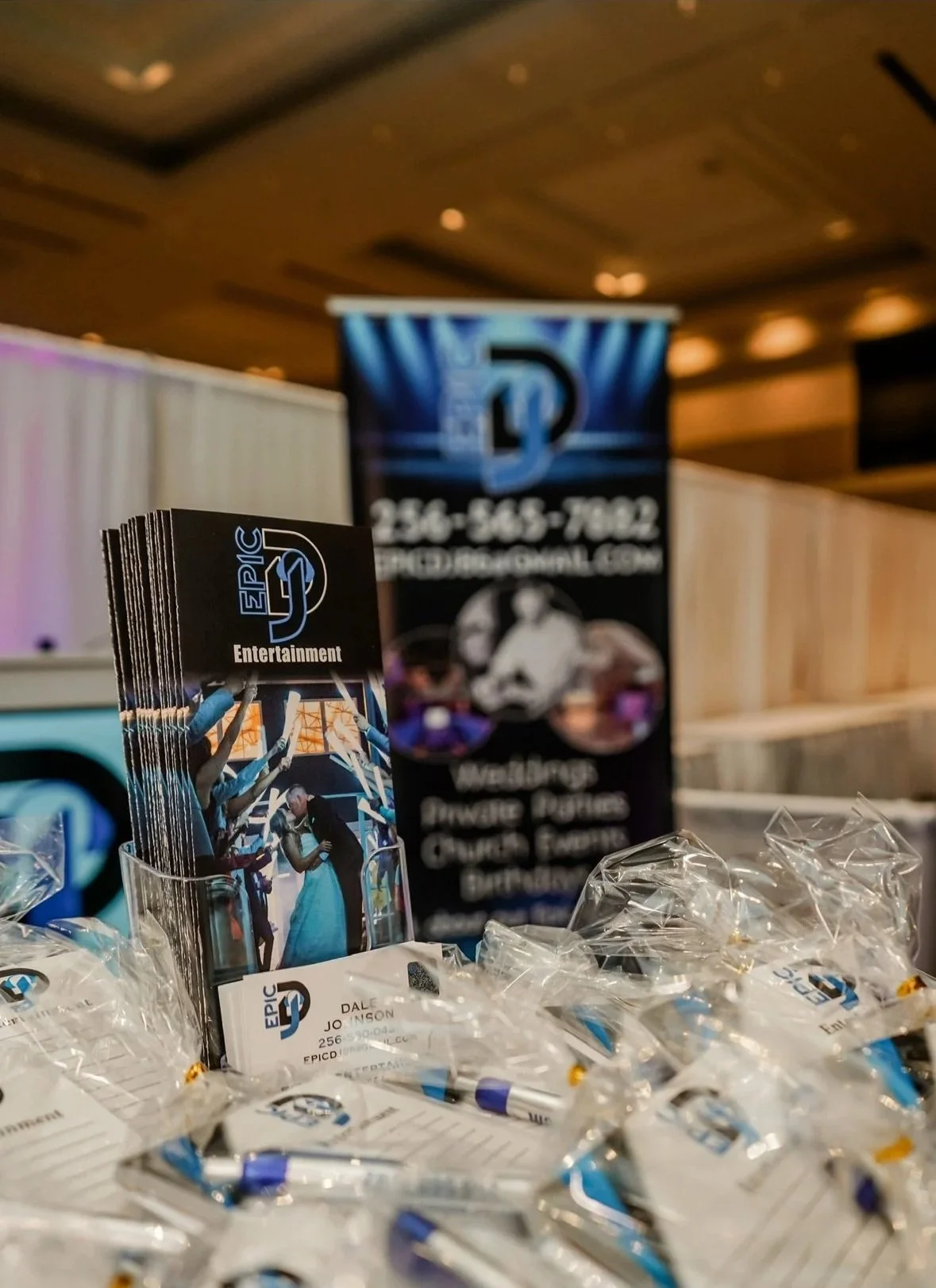 Pamphlets and business cards for Epic D Entertainment, with promotional materials and a blurred banner in the background.