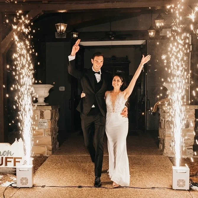 Young couple walking through Epic DJ Entertainment Cold Sparks during wedding.