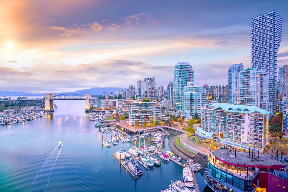 Vancouver skyline at sunset with marina, boats, and Burrard Bridge.