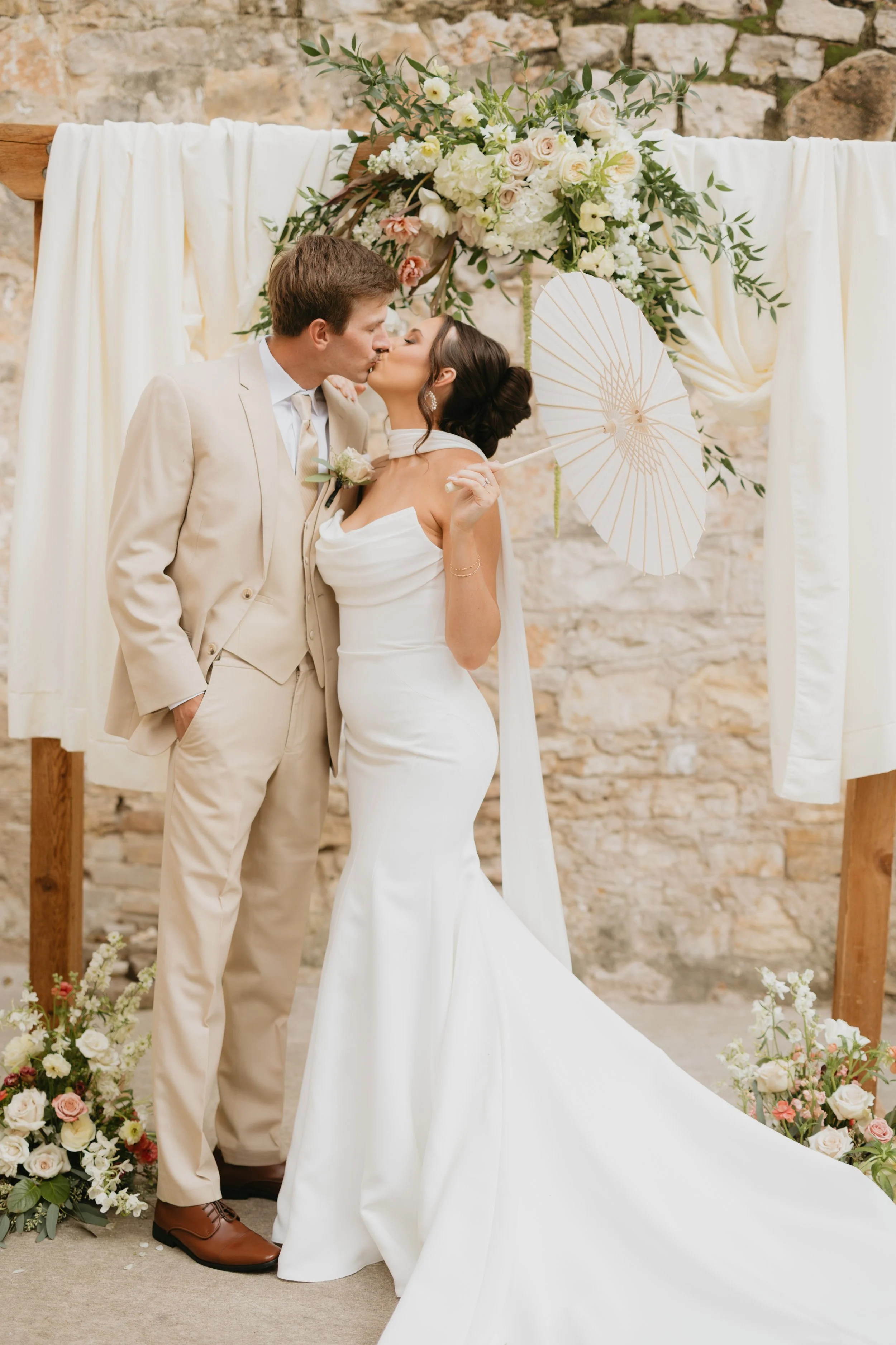 Bride and groom kissing at the altar