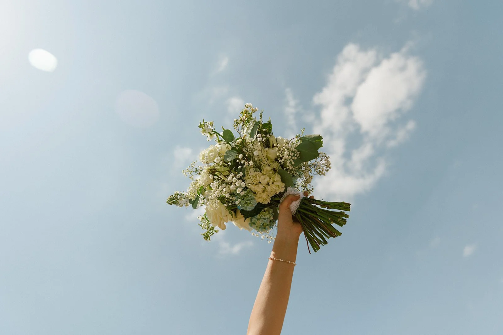 Bride holding her bouquet in the air