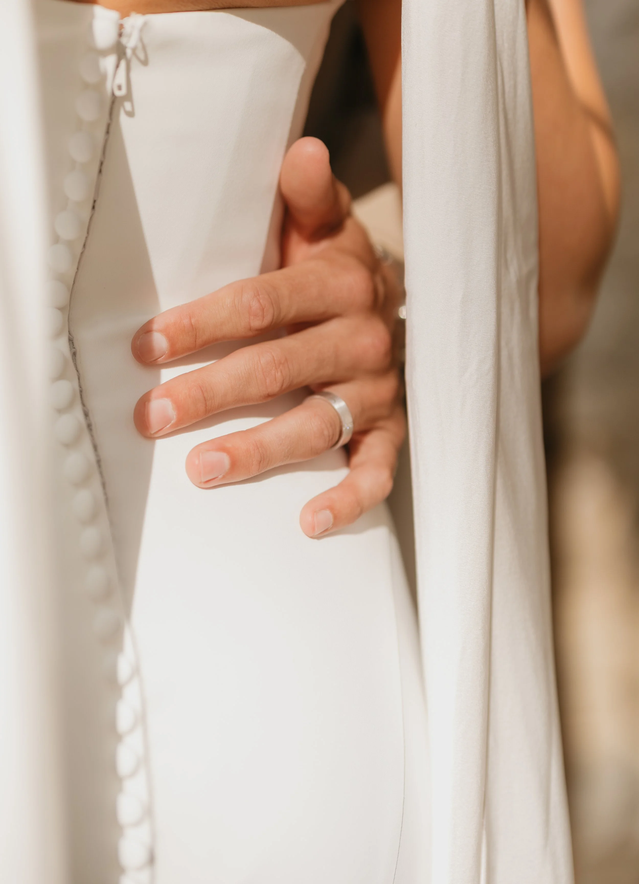 Groom's hand around bride's waist