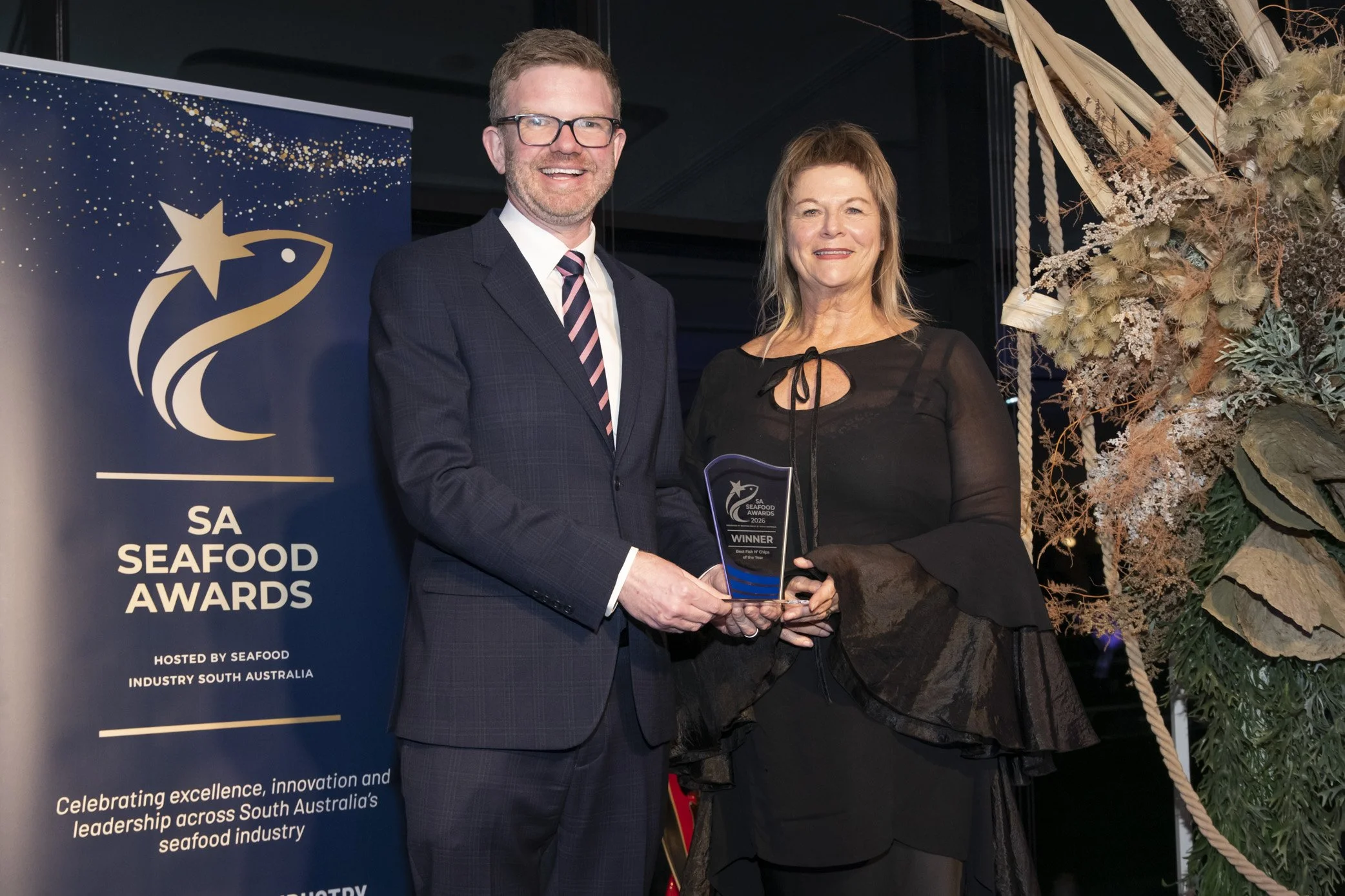 Event poster for the SA Seafood Awards 2026, hosted by Seafood Industry South Australia. Features a call for entries titled 'The Fish n Chips Award' with an image of fish and chips, a wedge of lemon, and two glasses of dipping sauces on a wooden surface with newspaper lining.