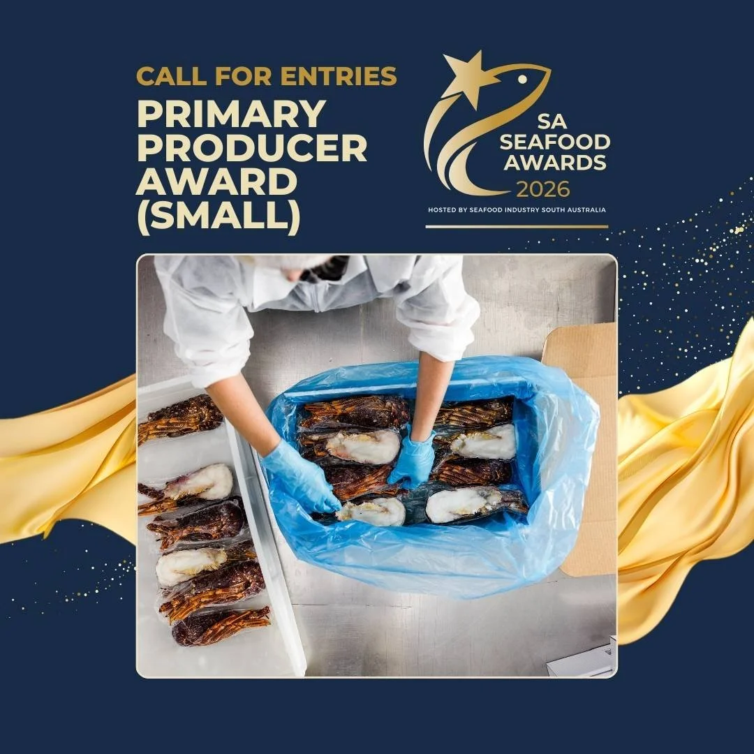 Person wearing white coat and blue gloves handling seafood in a blue plastic bag, with seafood arranged on a white surface and table.