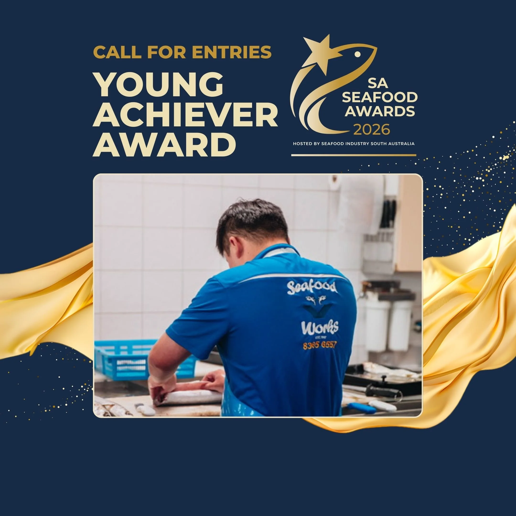 A person in a blue uniform preparing seafood in a kitchen, with the back of the uniform showing the words "Seafood" and a phone number.