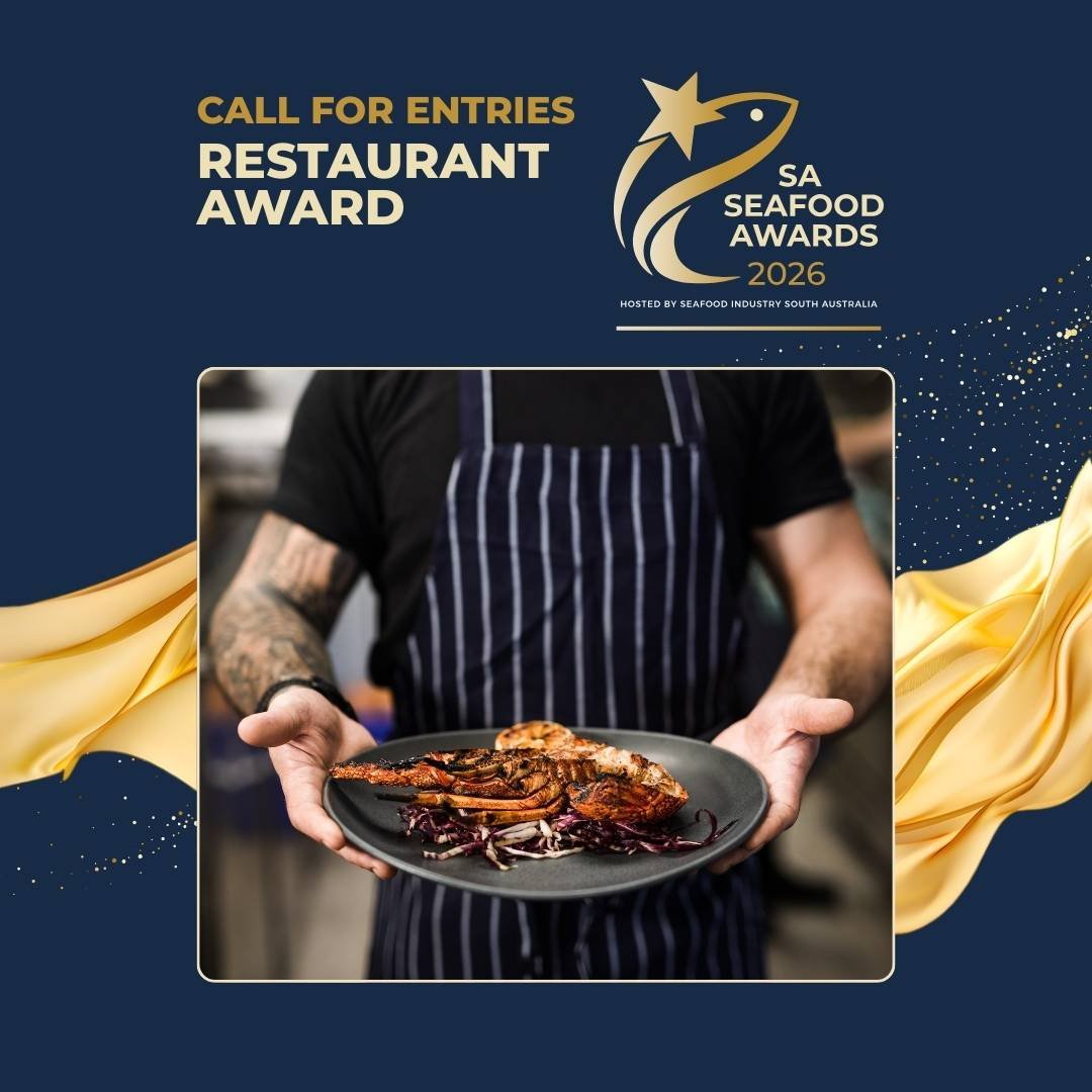 Person in black shirt and striped apron holding a black plate with a cooked lobster and garnishes, at the SA Seafood Awards 2026 event.