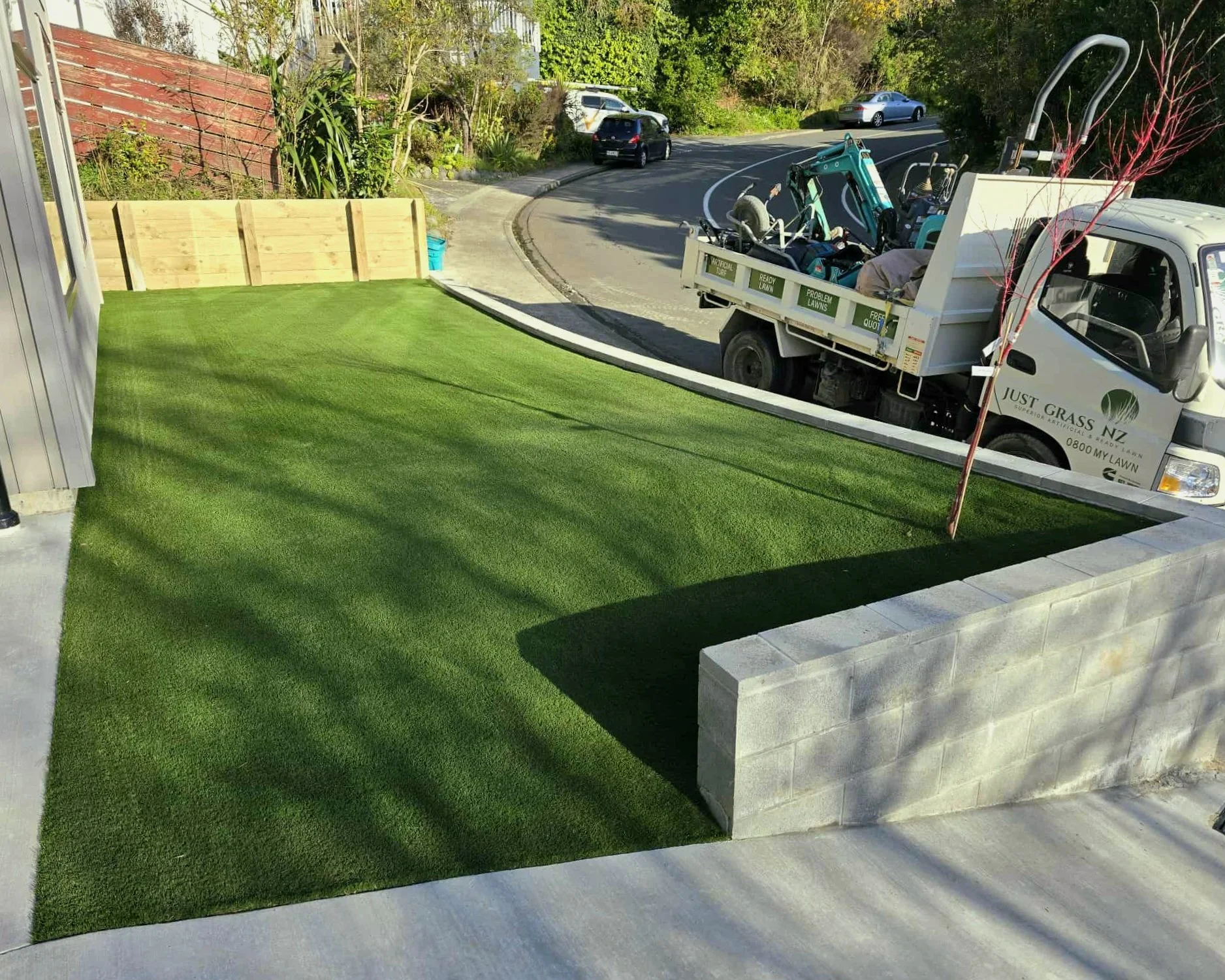 Street view green artificial grass installation front yard with Just Grass truck and digger