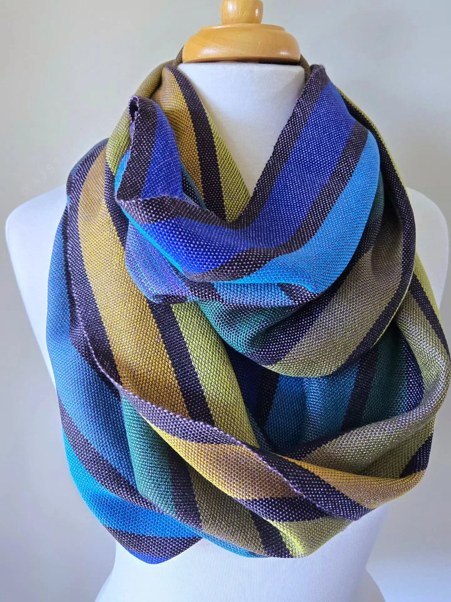 The close ups of scarf 4 and the last one in the Peacock Collection of handwoven scarves! 🦚

This one does some wild color shifting, it's weft is a lavender purple, but with the crossing over the greens, golds, and blues, it shifts to almost a silve