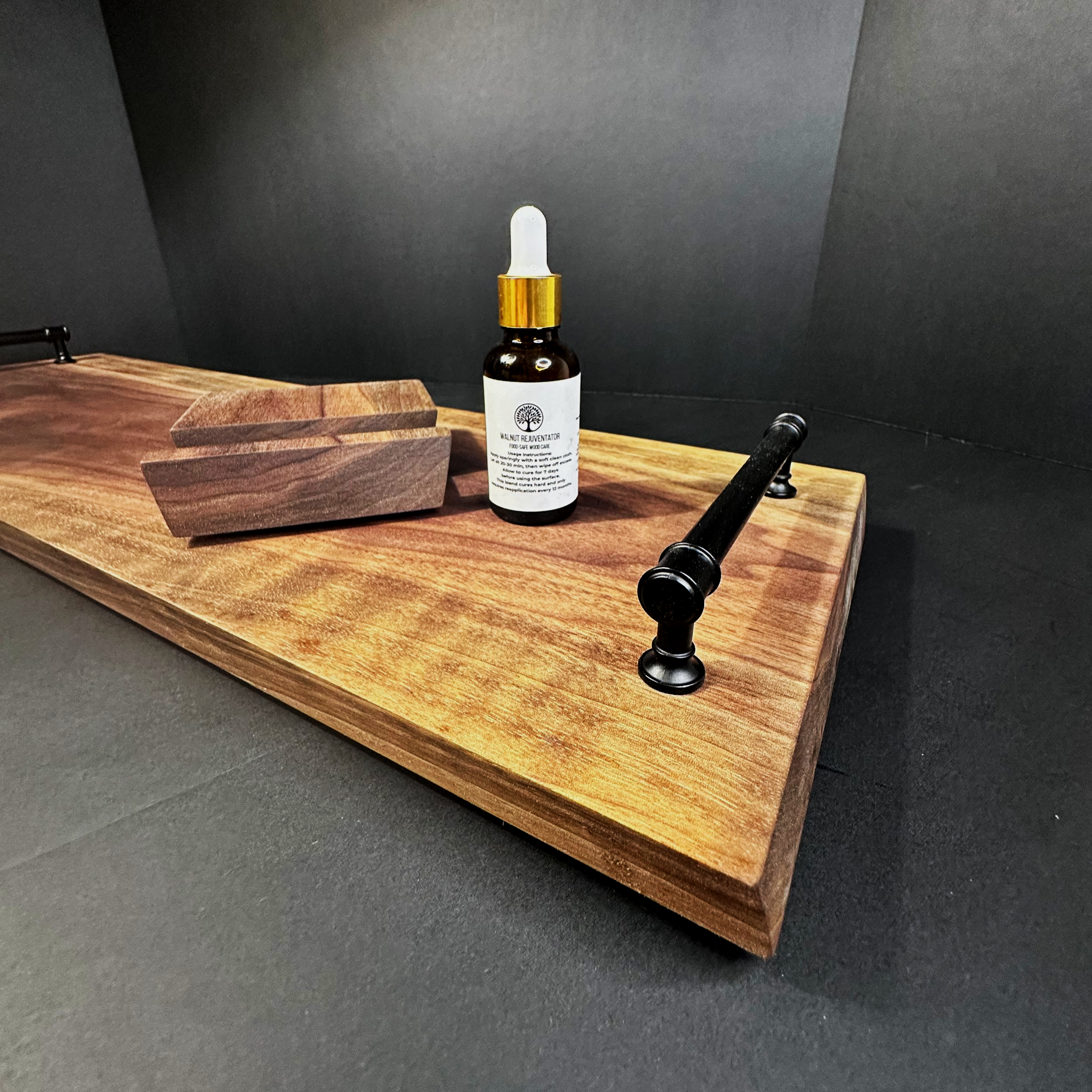 orange peel and tung oil blend bottle sitting on a curly walnut charcuterie board