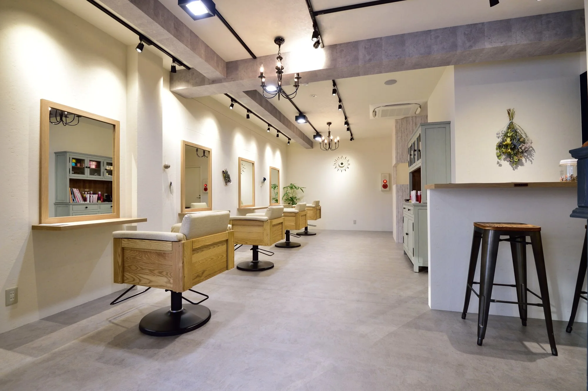 白い壁とソファ、鏡と棚が並ぶ明るいカフェの interior.