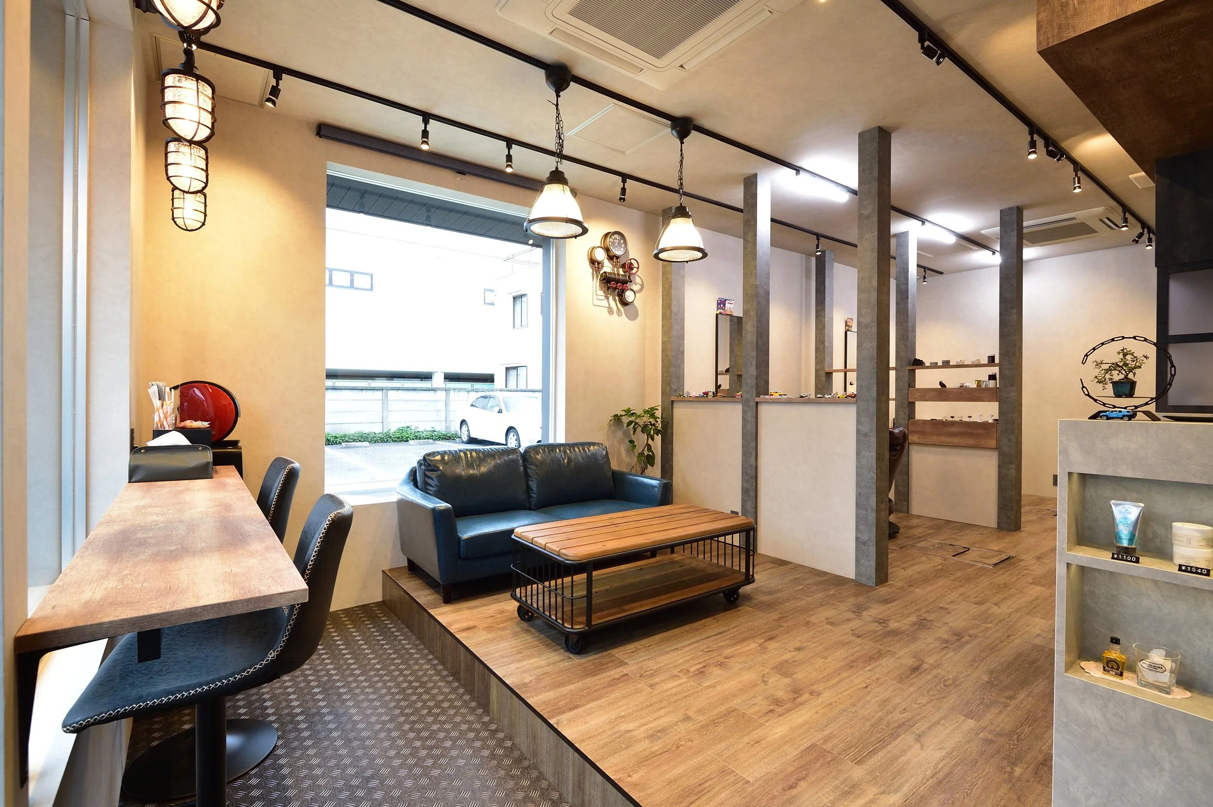 モダンなカフェの店内、照明と家具が配置され、窓から外の風景が見える