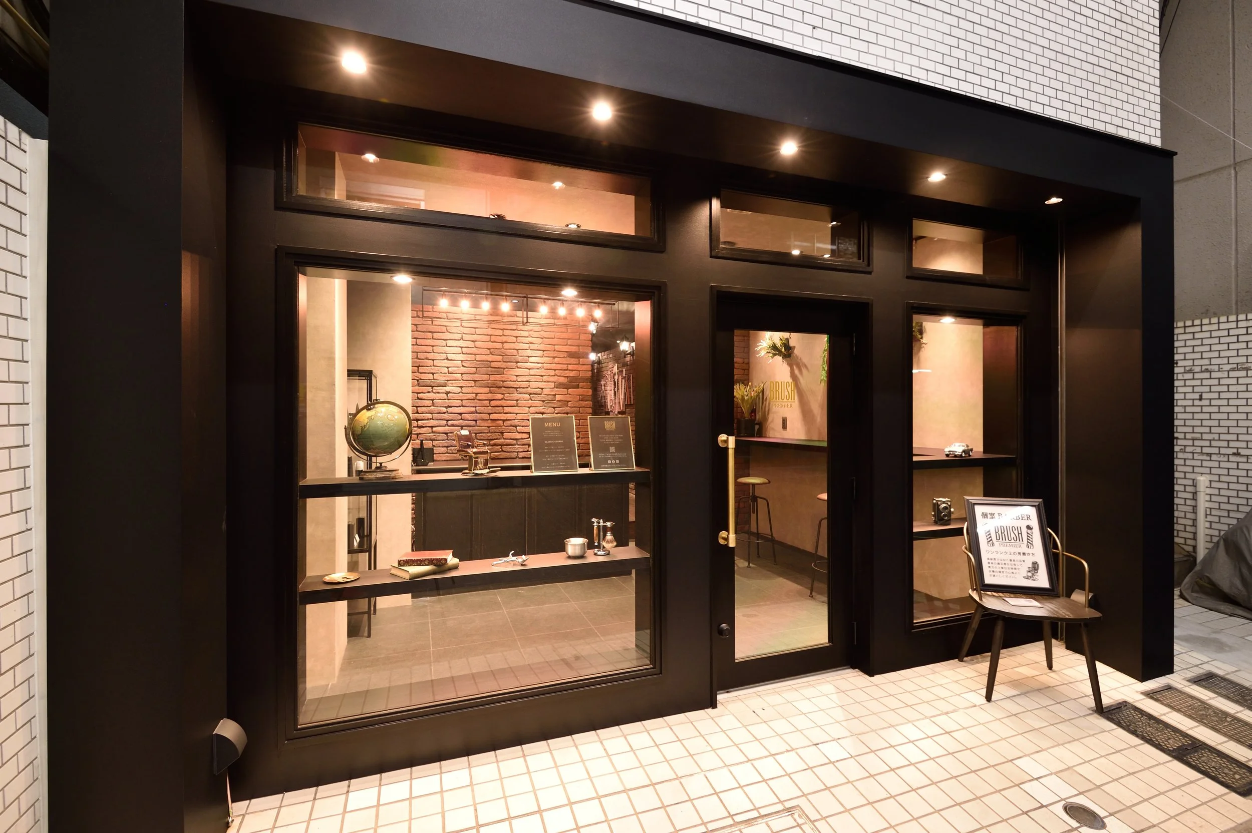 レストランの入り口から中を見た様子。レンガの壁とメニュー板、コーヒーカップや植物が飾られている。