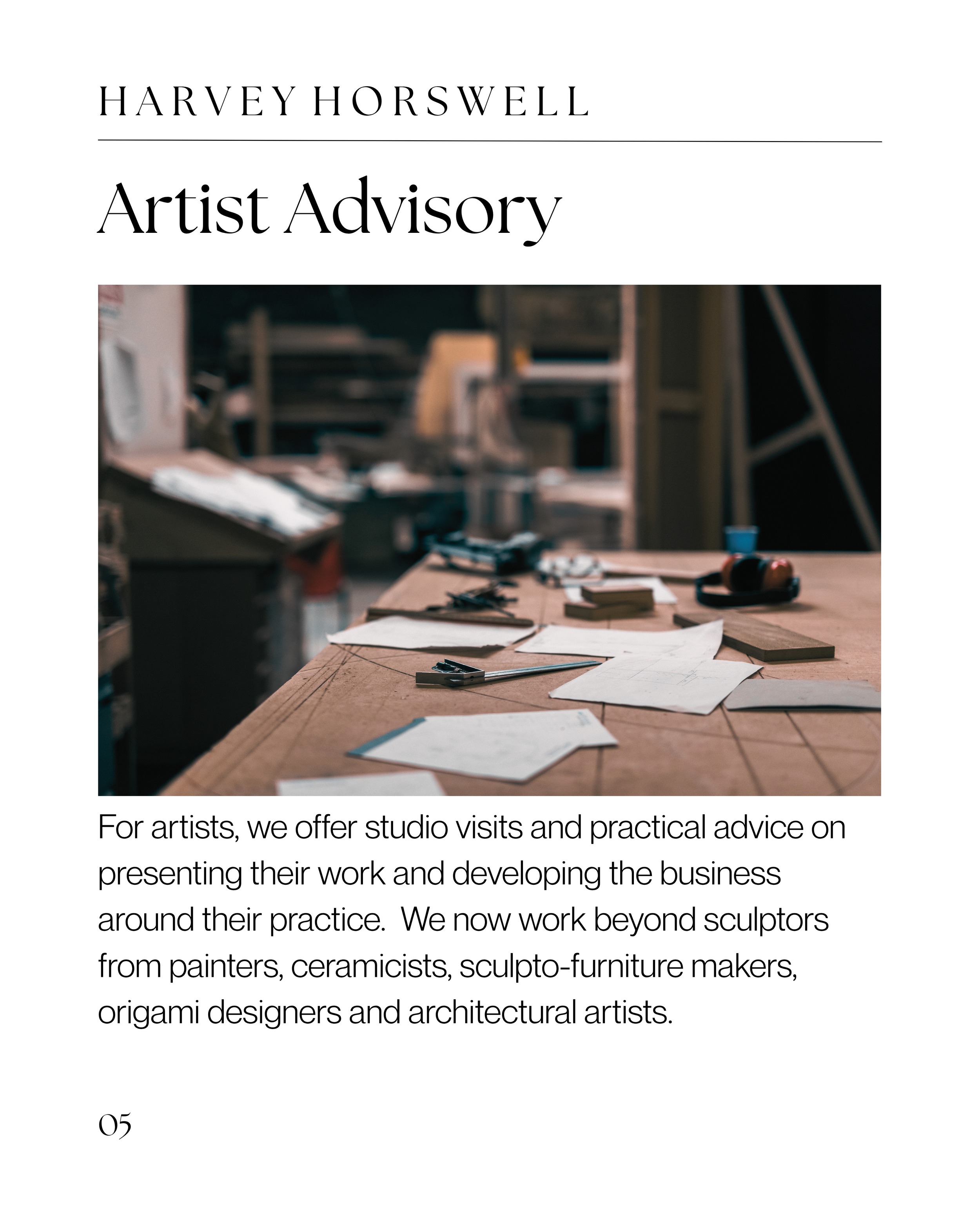Open sketchbook on a wooden table with drafting tools, papers, and a small wooden model in a craft studio.