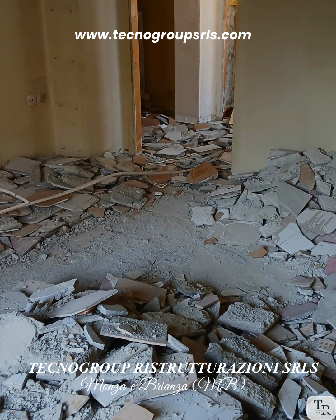 Room with damaged walls and debris on the floor, including broken tiles and dust, during renovation.