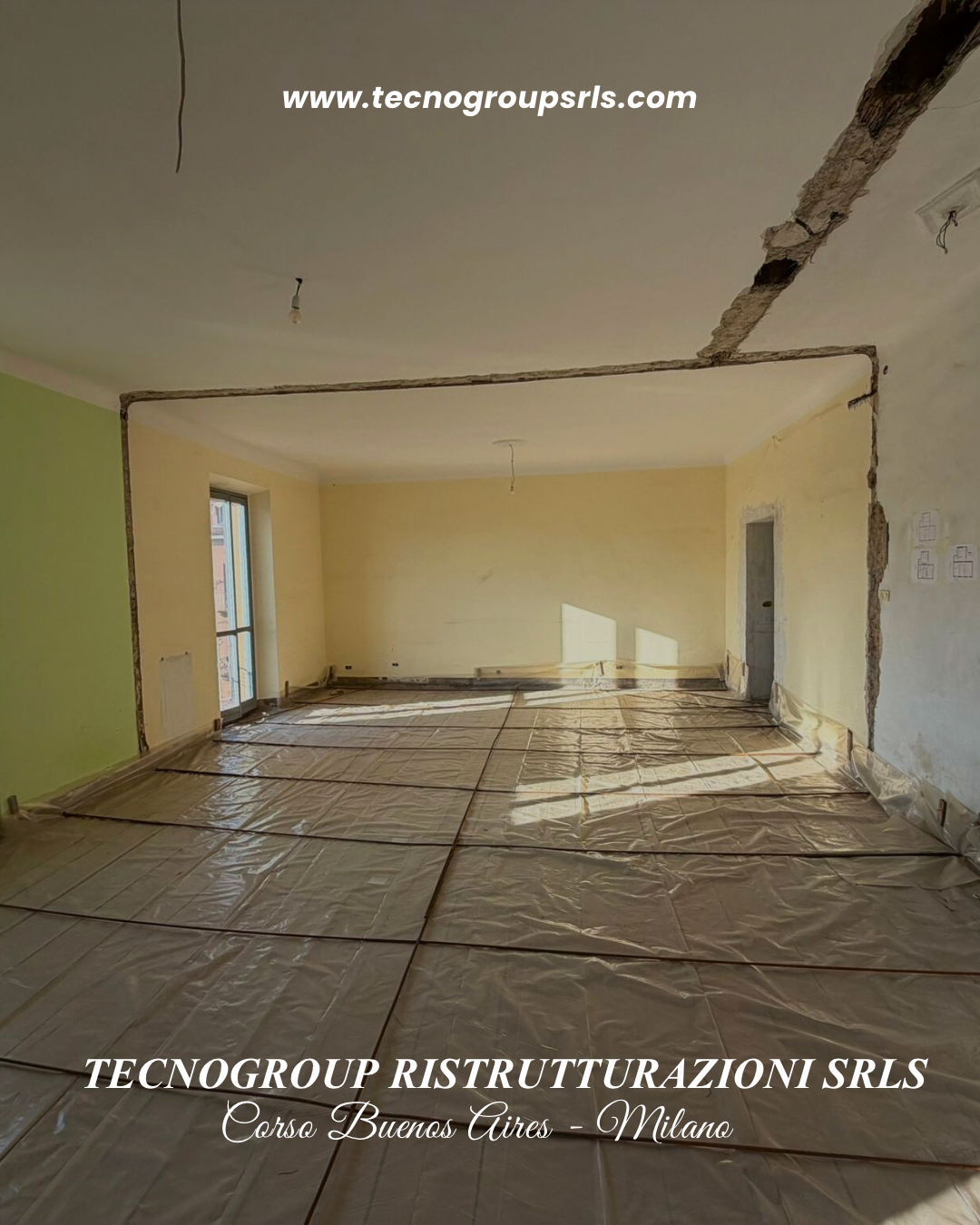 Interior room under renovation with partially removed walls, plastic covering on the floor, and a window letting in natural light.