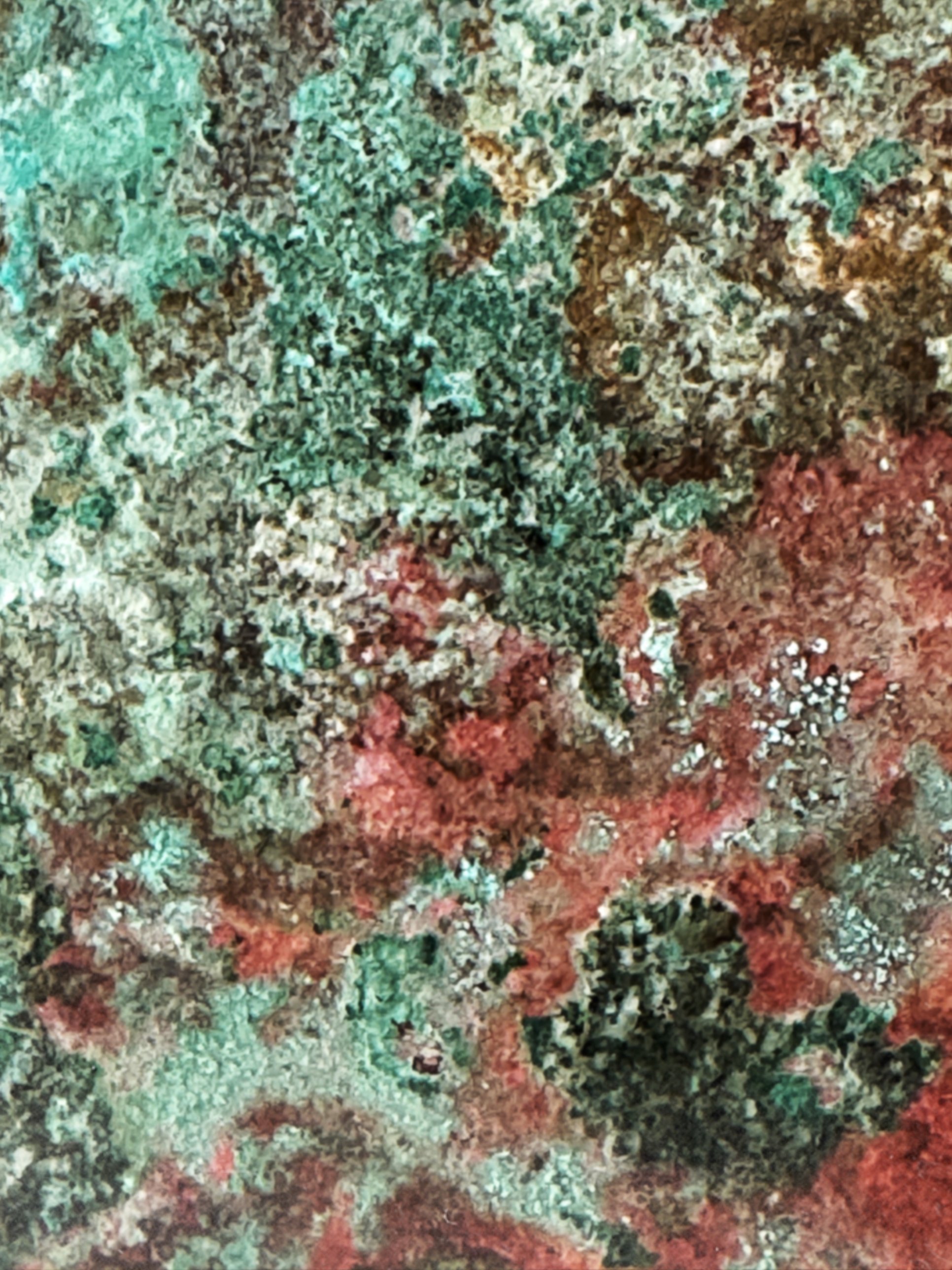 Macro detail of hand-developed patina on brass: teal, earthy brown and dusty rose