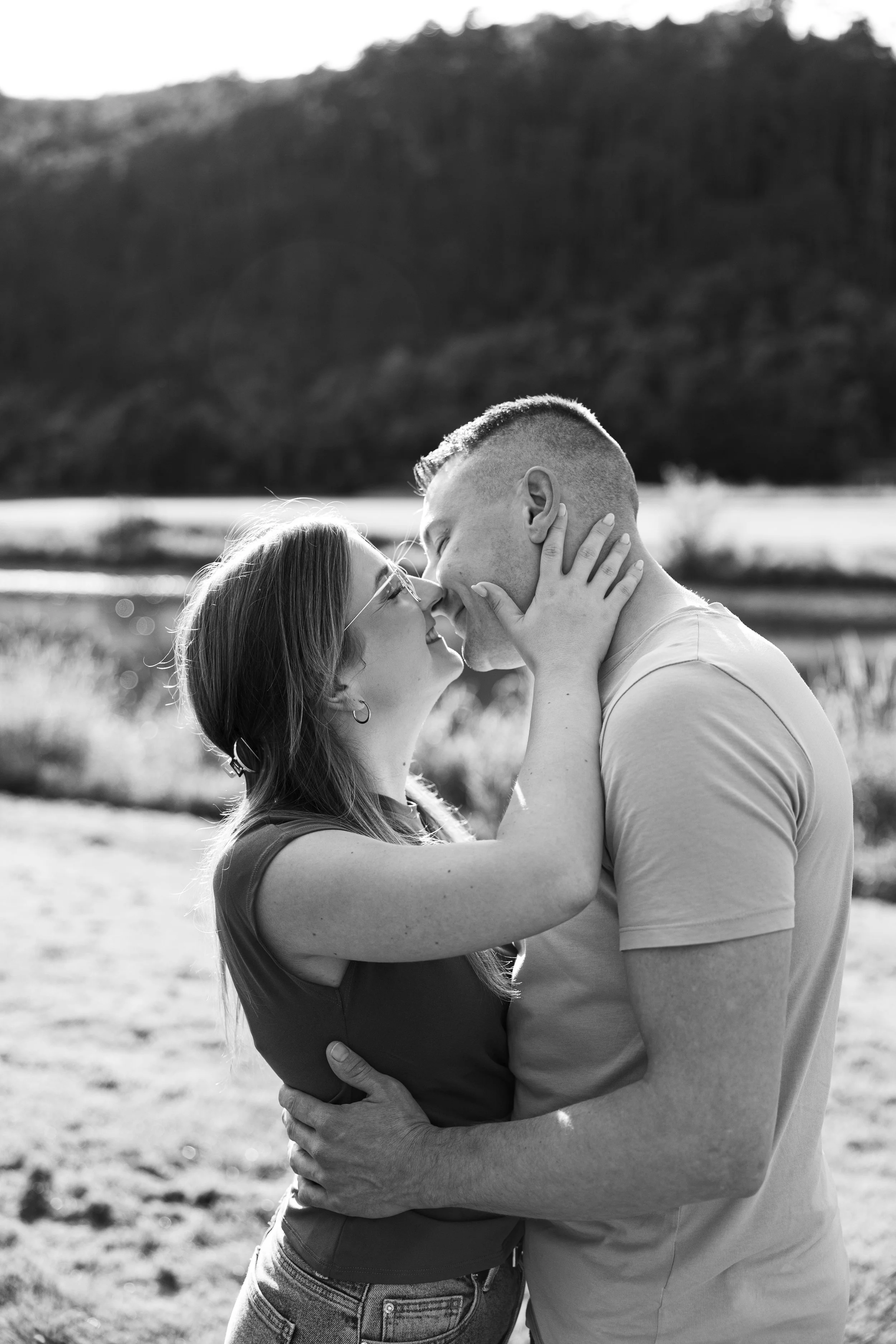 Paare in einer Naturlandschaft, die sich küssen. Schwarz-weiß Foto.