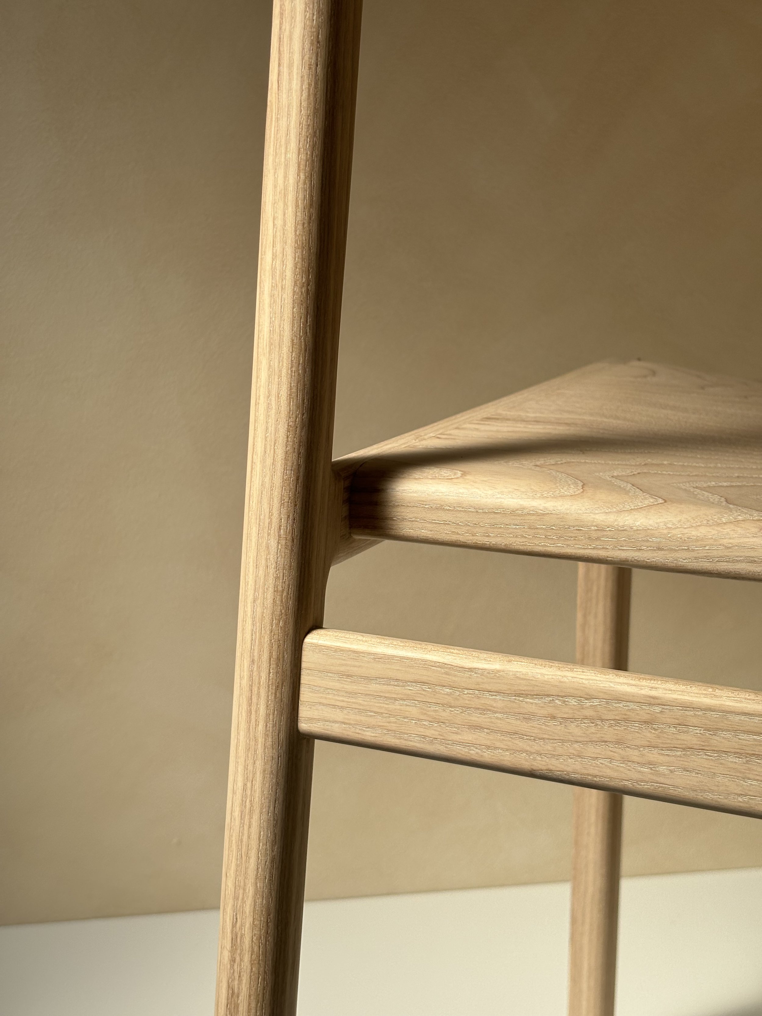 Eleven Chair by Mitch Polley Design, close up of back leg/seat detail. A contemporary dining chair with a curved backrest and scooped seat, handmade in English ash.