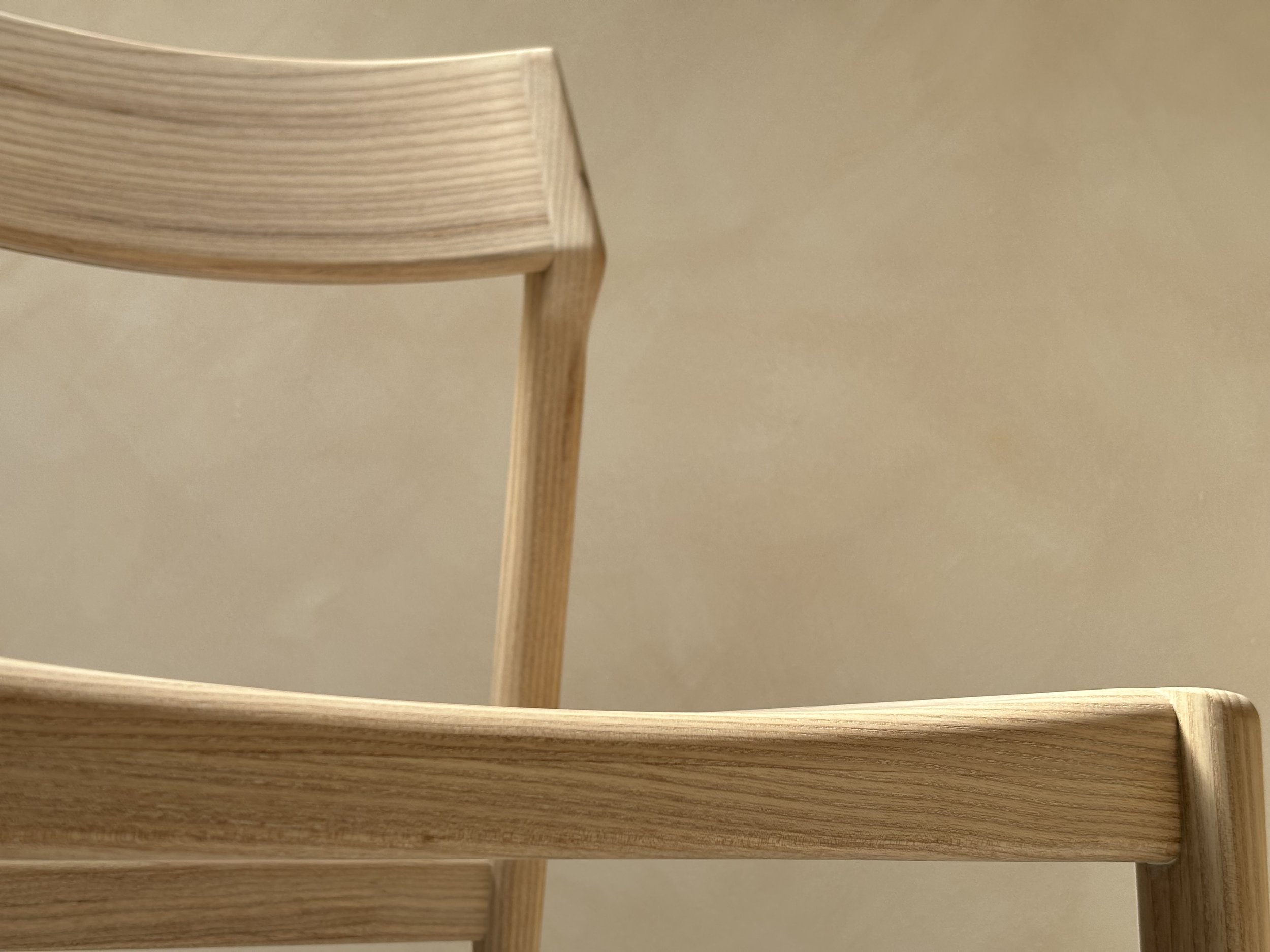 Eleven Chair by Mitch Polley Design, close up of seat detail. A contemporary dining chair with a curved backrest and scooped seat, handmade in English ash.