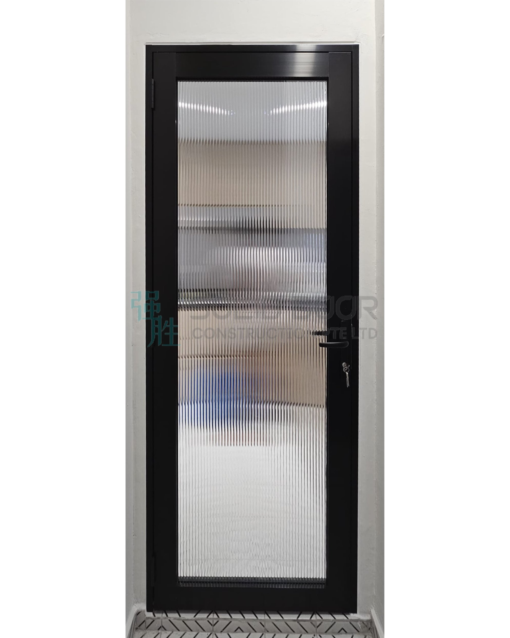 Black metal door with frosted ribbed glass window and a door handle with a keyhole.