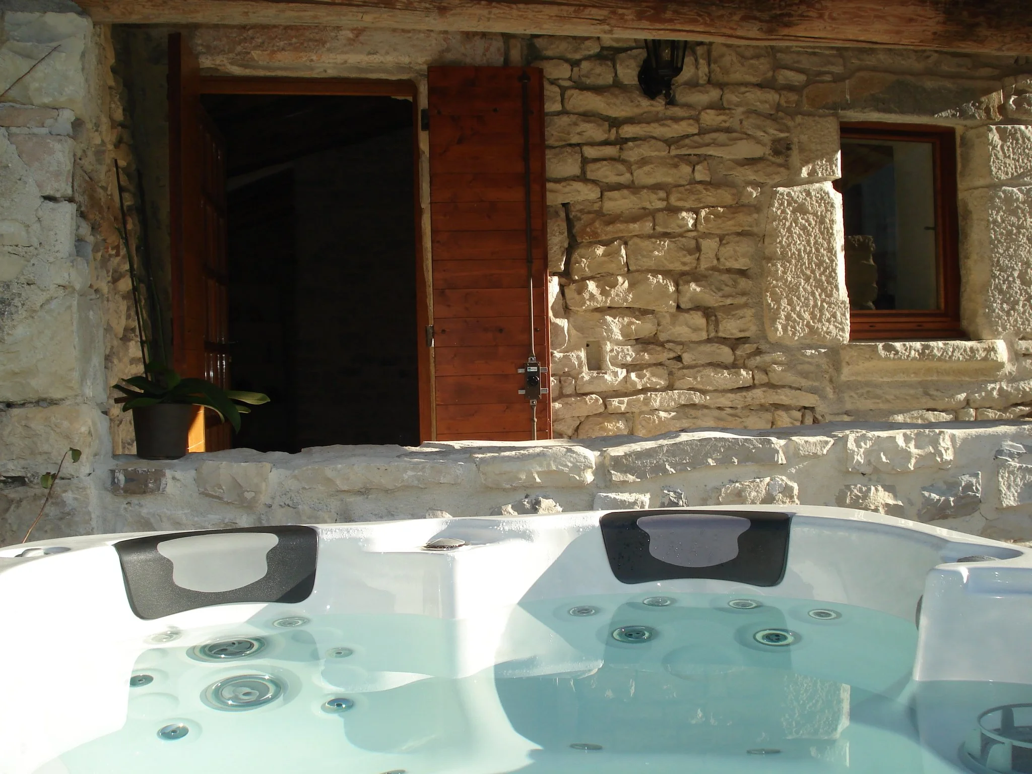 Steinmauer und privater Whirlpool in rustikaler Ferienunterkunft