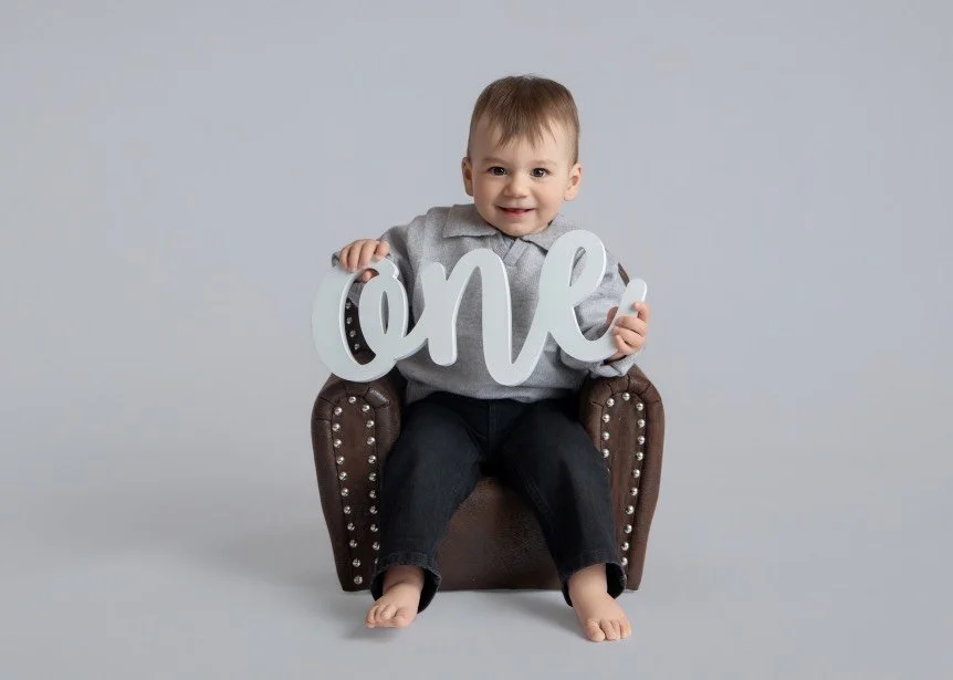 Joyful sitter baby milestone portrait in a light, timeless studio setting serving Central NJ families