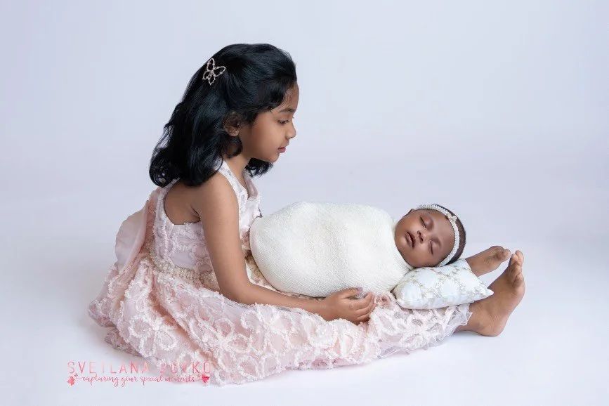 Newborn baby photographed with an older sibling during a studio newborn session serving Bucks County, PA