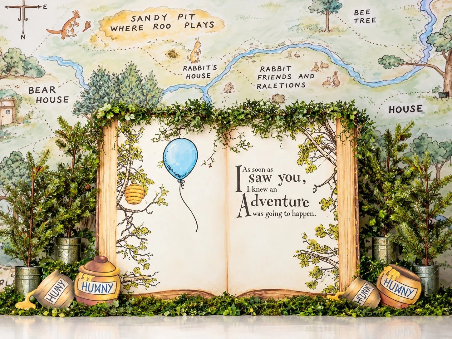 Storybook-inspired cake smash backdrop with a woodland map, honey pots and greenery for first birthday photography sessions in Mercer County, NJ.