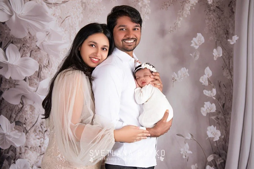 Timeless family newborn portrait featuring parents with their sleeping baby in a soft studio setting in NJ.