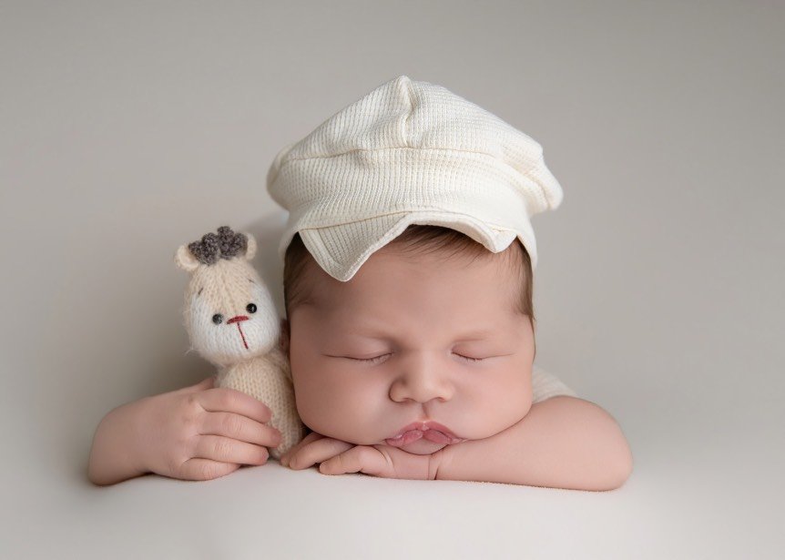 Sleeping newborn baby photographed in a Mercer County, NJ studio, posed safely in a soft, neutral setup.