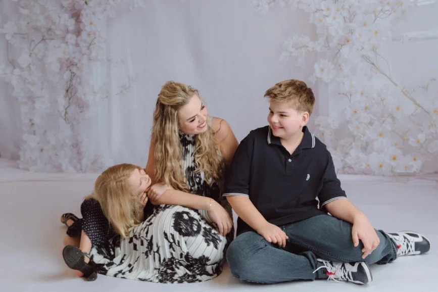 Mother’s Day studio portrait of mom with her son and daughter in West Windsor NJ, soft floral backdrop, elegant mommy and me photography session