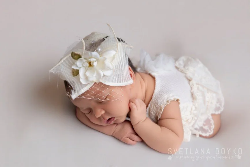 Luxury posed newborn photography featuring a sleeping baby girl in a styled studio setup in New Jersey