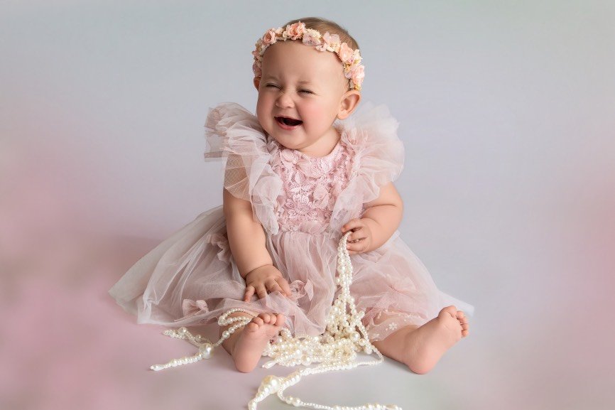 Smiling sitter baby girl photographed during a milestone session in Mercer County, NJ