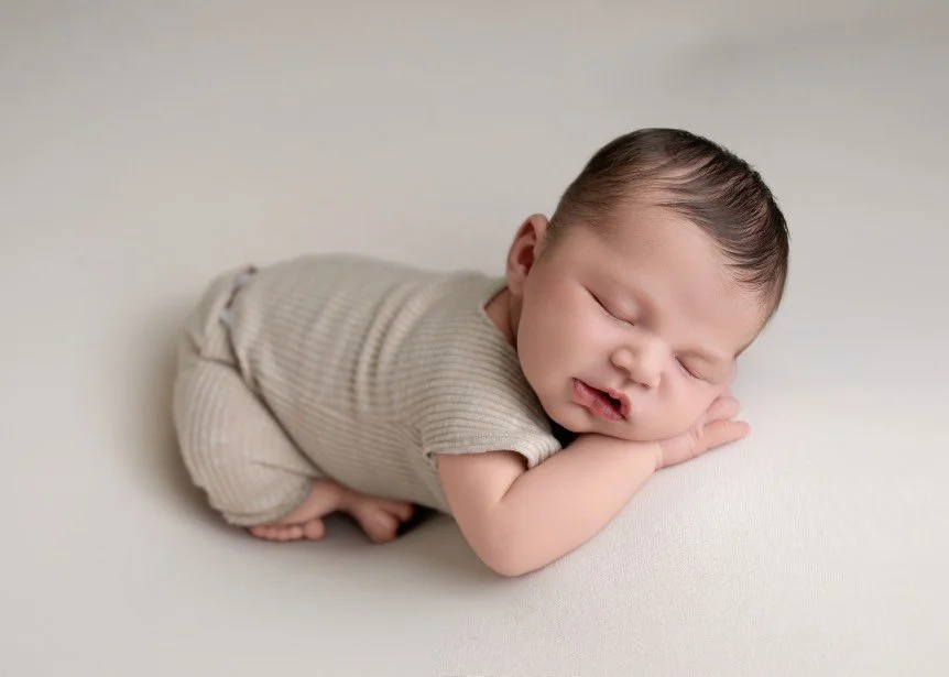 Safety-focused posed newborn photography of a sleeping baby girl in a Central New Jersey studio