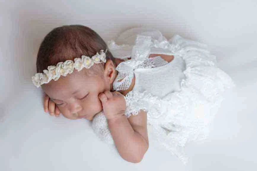 Safety-focused posed newborn photography of a sleeping baby girl in a Central NJ studio.